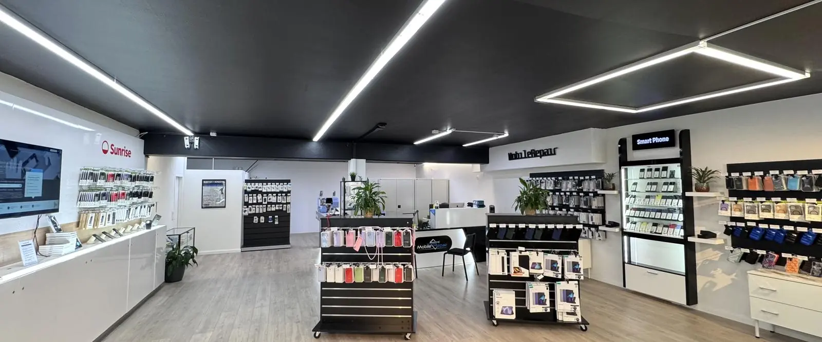Intérieur du magasin Mobile-Repair à Nyon : présentoirs, vitrine de smartphones et comptoir de réparation